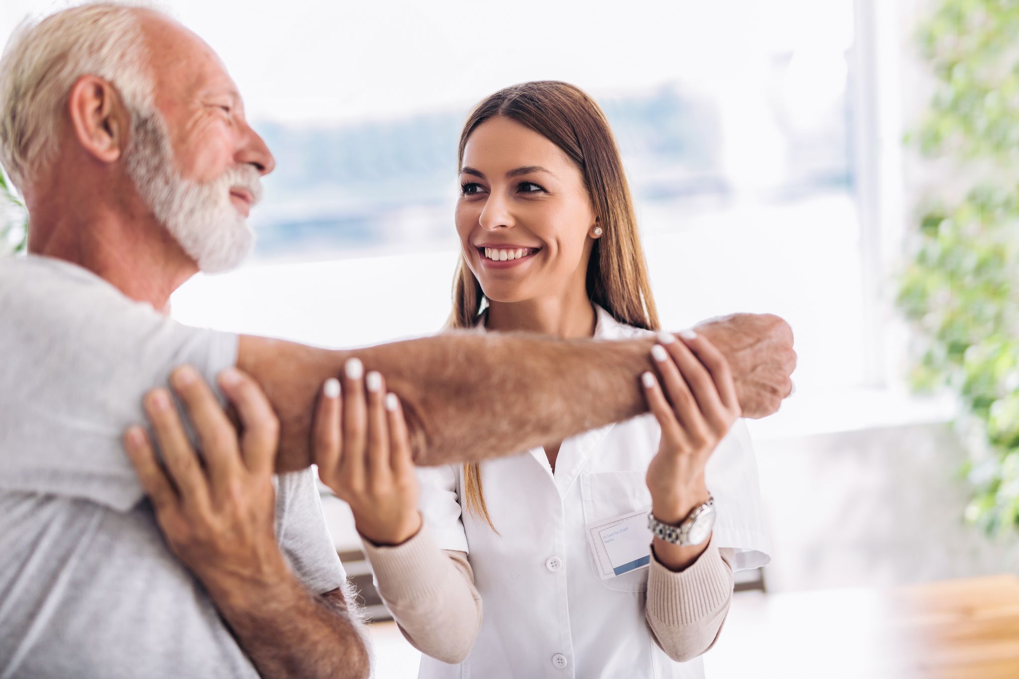 Man having chiropractic arm adjustment. Physiotherapy, sport injury rehabilitation. Senior man exercises in center for chiropractic.